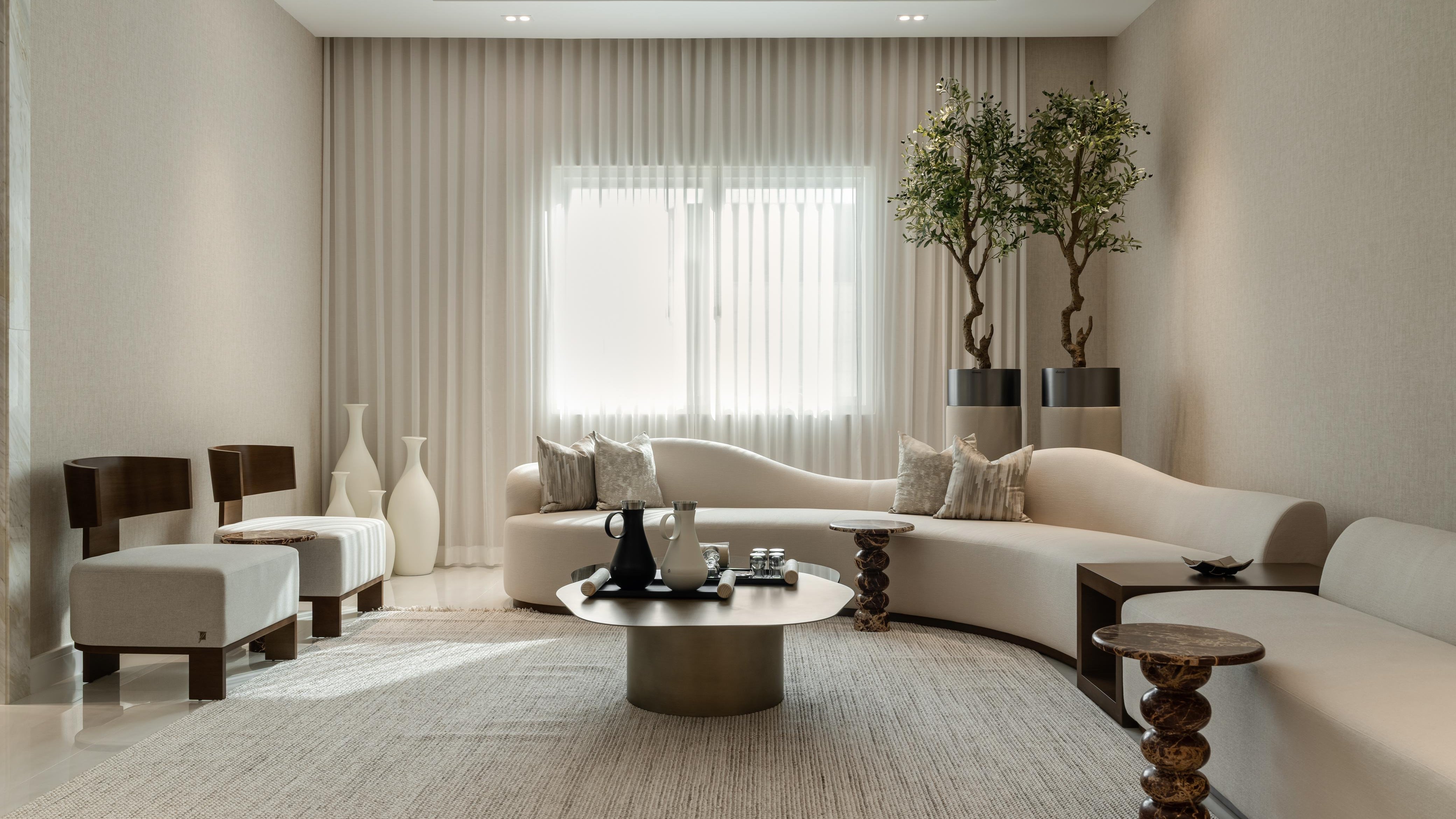 Modern living room with beige walls, a white sofa, and decorative elements.